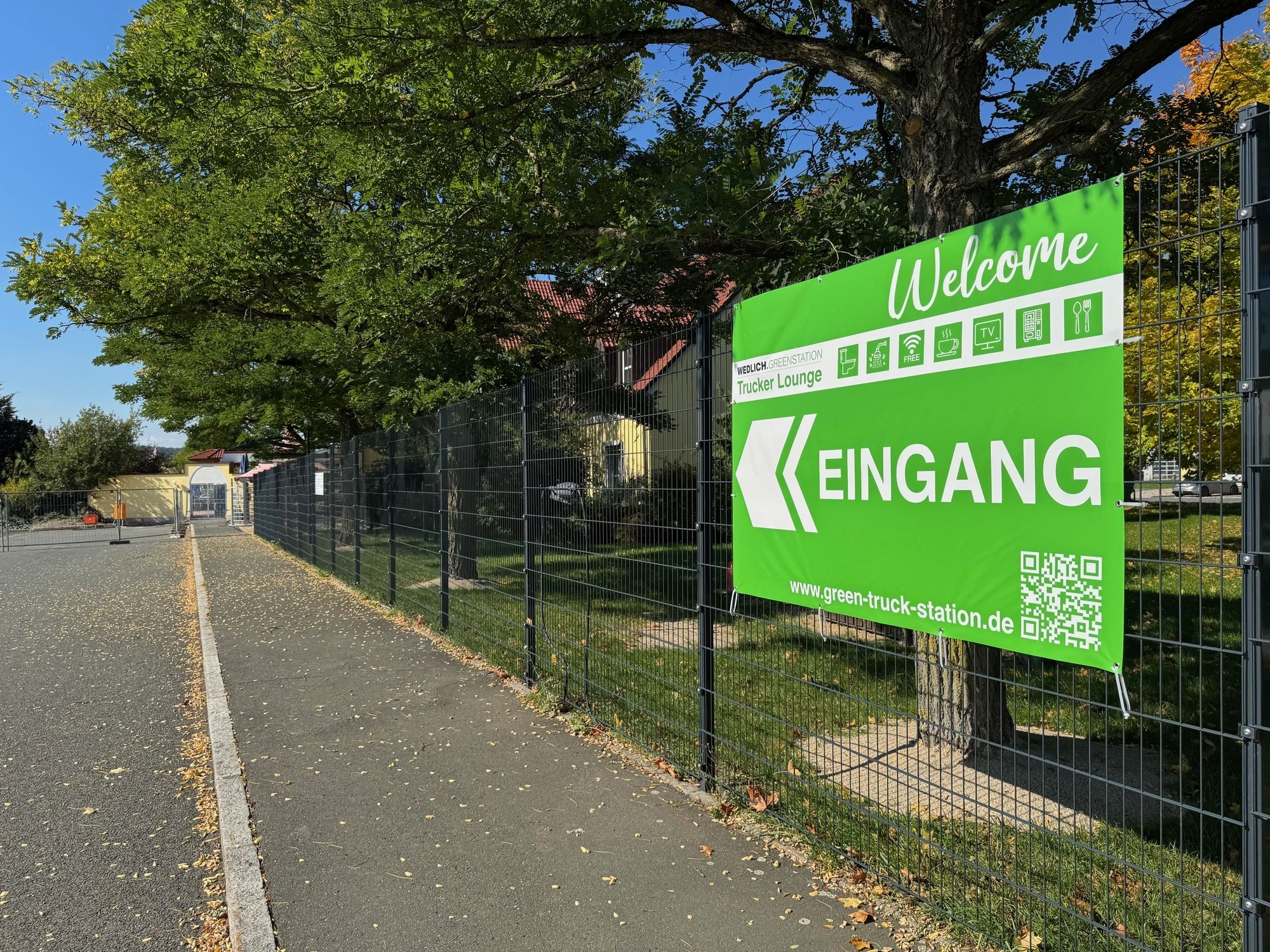 Ein grünes Schild mit einem weißen Richtungspfeil darauf.